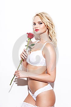 blonde woman in underwear holding rose