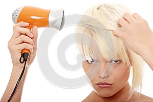 Blonde woman using hair drier