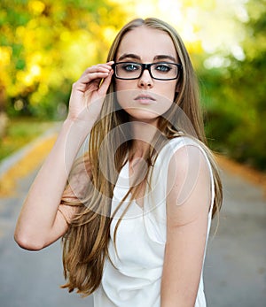 Blonde woman wearing eyeglasses and white blouse