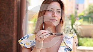 blonde woman wearing sunglasses with a modern outfit