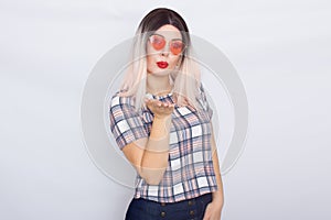 Blonde woman wearing sunglasses over white background