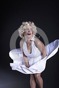 blonde woman in a white dress in the style of Marilyn Monroe cheerful and funny