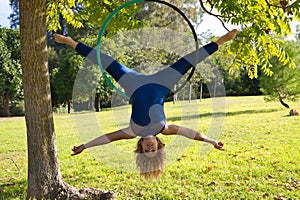 Blonde woman and young gymnast acrobat athlete performing aerial exercise on air ring outdoors in park. Lithe woman in blue photo