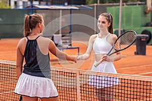 Blonde women tennis players shaking hands over net