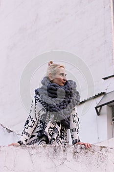 Blonde young beautiful fashion girl wearing aztec black and white jacket and knitted grey vest scarf. Festival outfit