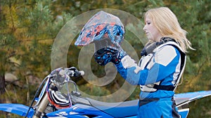Blonde young Girl Bike wears a helmet - MX moto cross racing - rider on a dirt motorcycle photo