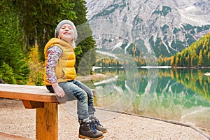 Blonde young girl sitting on picnic table at Lake Bries