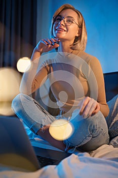 Blonde young girl working on computer in bed