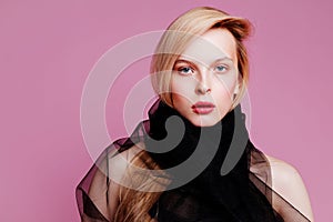 Blonde young woman in elegant body. Girl posing on a pink background. Make -up and hairstyle. Fashion photo