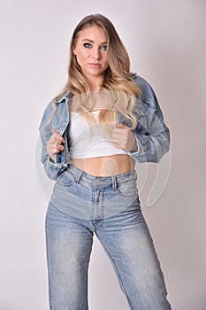 Blonde young woman with jeans jacket and trousers