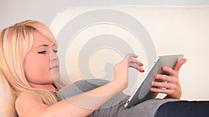 Blondhaired woman surfing on her tablet