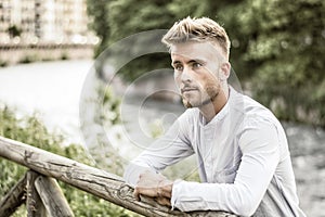 Blondish, blue eyed young man by river