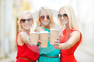 Blonds holding takeaway coffee cups in the city