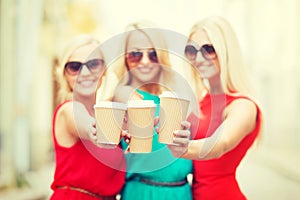 Blonds holding takeaway coffee cups in the city