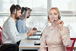 Blont mature woman using headset. photo