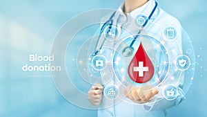 Blood Donation concept. World blood donor day awareness. Doctor holding in hand drop of blood with medical cross icon and medicine