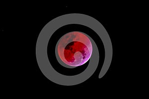 Blood moon concept of a red full moon against black sky