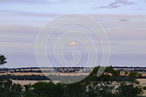 Blood moon rising over rural Australian landscape