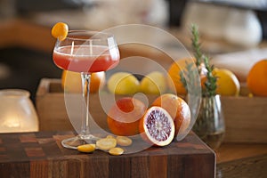 Blood orange alcohol beverage with ingredients in background