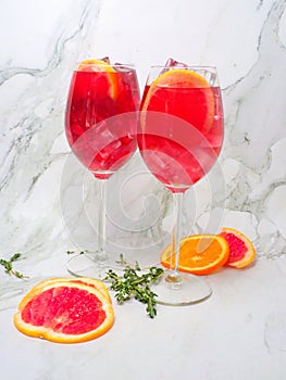 Blood orange spritzer styled with sliced blood oranges and slices of oranges and thyme