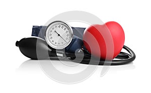 Blood pressure meter and toy heart on white background