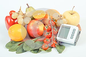 Blood pressure monitor and fresh ripe fruits with vegetables, healthy lifestyle