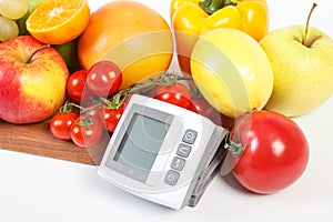 Blood pressure monitor and fresh ripe fruits with vegetables, healthy lifestyle concept