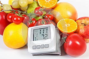 Blood pressure monitor and fresh ripe fruits with vegetables, healthy lifestyle and nutrition