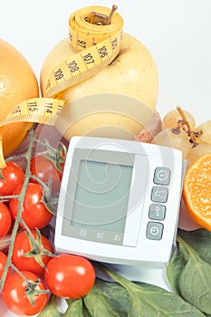 Blood pressure monitor, fruits with vegetables and centimeter