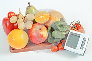 Blood pressure monitor and fruits with vegetables, healthy lifestyle