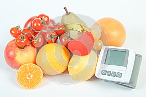 Blood pressure monitor and ripe fruits with vegetables, healthy lifestyle