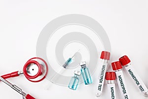 Blood sample tube for Monkeypox virus test, stethoscope and syringe with vaccine form pox on white background. photo