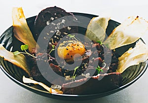 Blood sausage and dry cured chorizo tempered tartare with edamame and egg yolk cured in soy