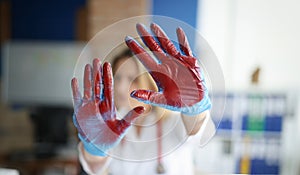 Bloodied hand in doctor medical gloves in clinic