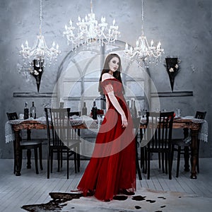 Bloodthirsty female vampire in red dress. Medieval interior photo