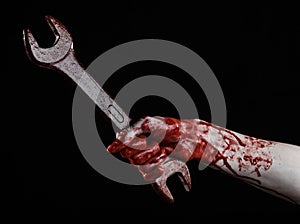 Bloody hand holding a big wrench, bloody wrench, big key, bloody theme, halloween theme, crazy mechanic, black background