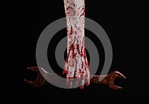 Bloody hand holding a big wrench, bloody wrench, big key, bloody theme, halloween theme, crazy mechanic, black background