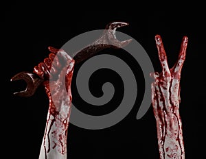 Bloody hand holding a big wrench, bloody wrench, big key, bloody theme, halloween theme, crazy mechanic, black background