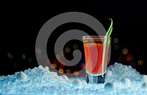 Bloody Mary cocktail close-up, decorated with greenery, in a surreal landscape on a black background with a fabulous