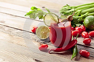 Bloody Mary cocktail garnished with gherkin, olive, lime, and celery