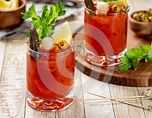Bloody mary cocktail with garnishes on wooden table