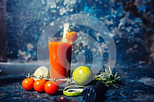 Bloody Mary cocktail served on a dark bar garnished with cherry tomatoes