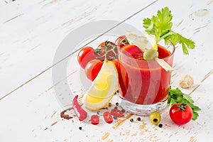 Bloody Mary ingredients on white wood background