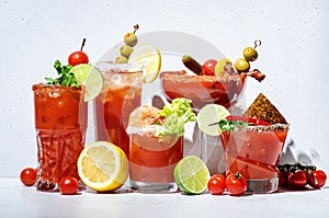 Bloody Mary, Joseph, Caesar and other red cocktails set with tomato juice, vodka, hot sauce and celery. Cocktail party. Gray