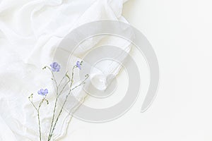 Blooming flax flowers on a white background on light-colored textiles.