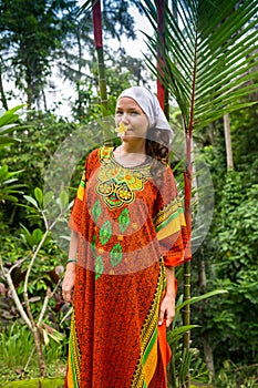 Blooming gorgeous lady in a dress of flowers in the rainforest