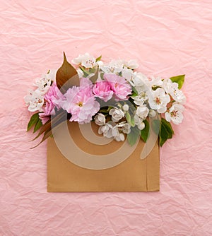 Blooming sakura and white cherry tree. Envelope with spring flowers over pink crumpled decorative paper background