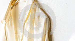 A blouse or shirt in white hanging on clothes hanger on white background.Close up