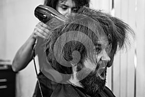 blow dry hair in barbershop of brutal mature shouting client man, hairdresser