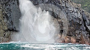 Blow Hole in Diorite rocks with a blast of water off the Coast of Bruny Island Tasmania Australia